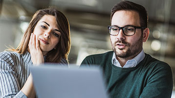 man and woman at a computer discussing supply chain strategy
